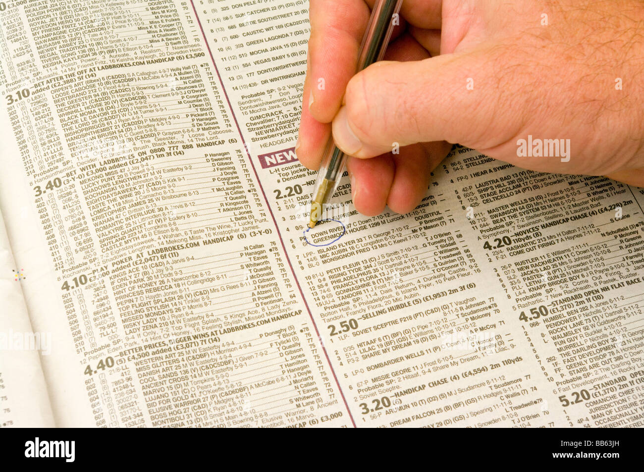 Mans Hand With A Pen Making a Horse Selection In A Newspaper Stock Photo