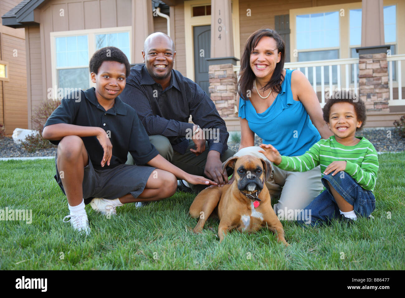 Family with dog in grass by home Stock Photo