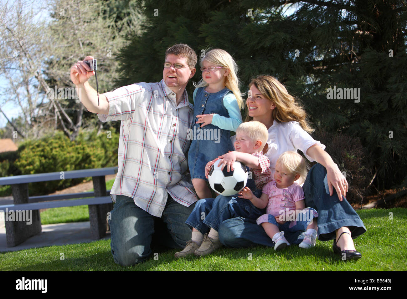 Family with camera taking a self portrait at park Stock Photo