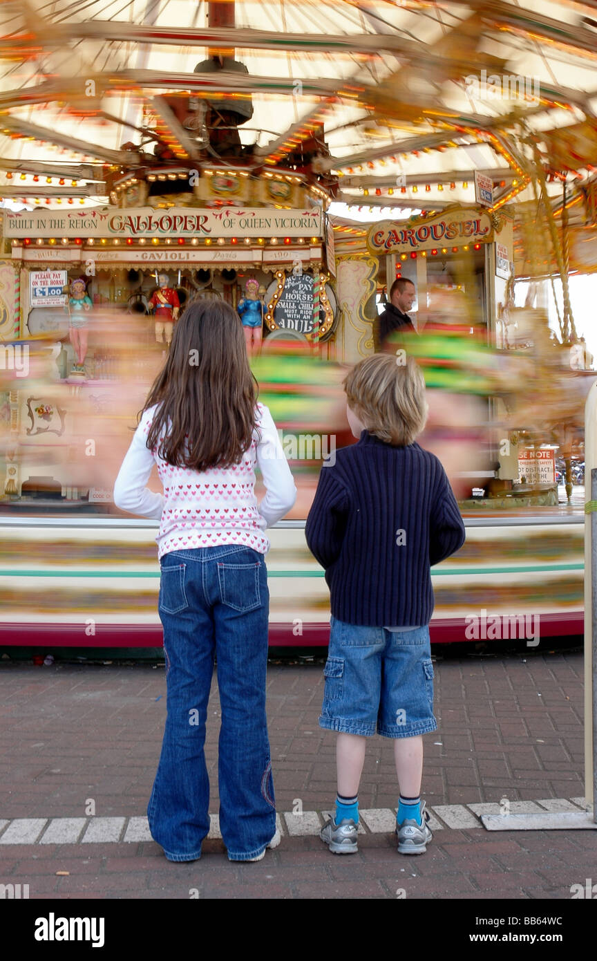 A boy and girl wait for the carousel at the funfair Stock Photo