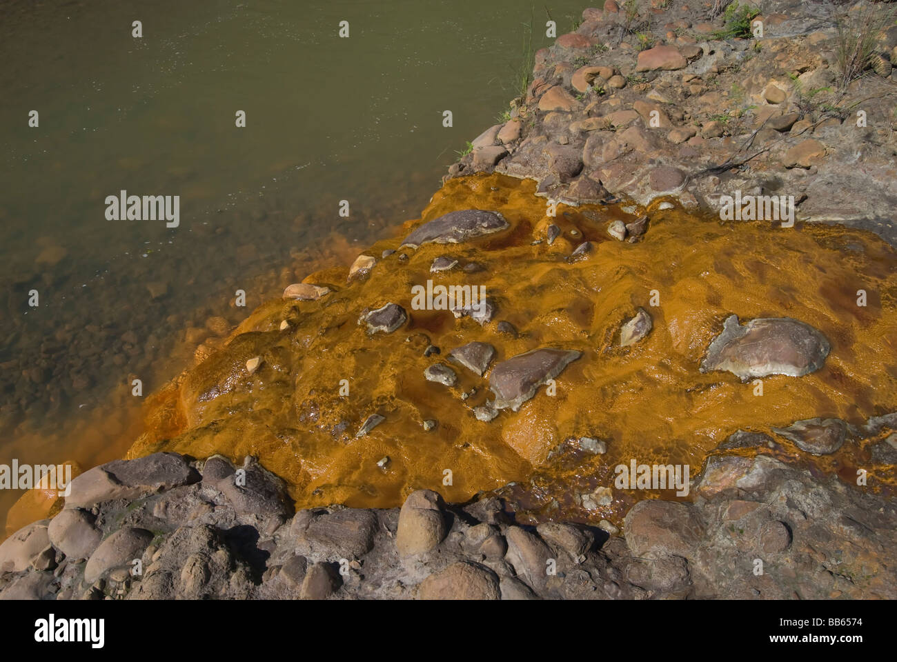 Polluted disposal of a coal mine into a river. Stock Photo