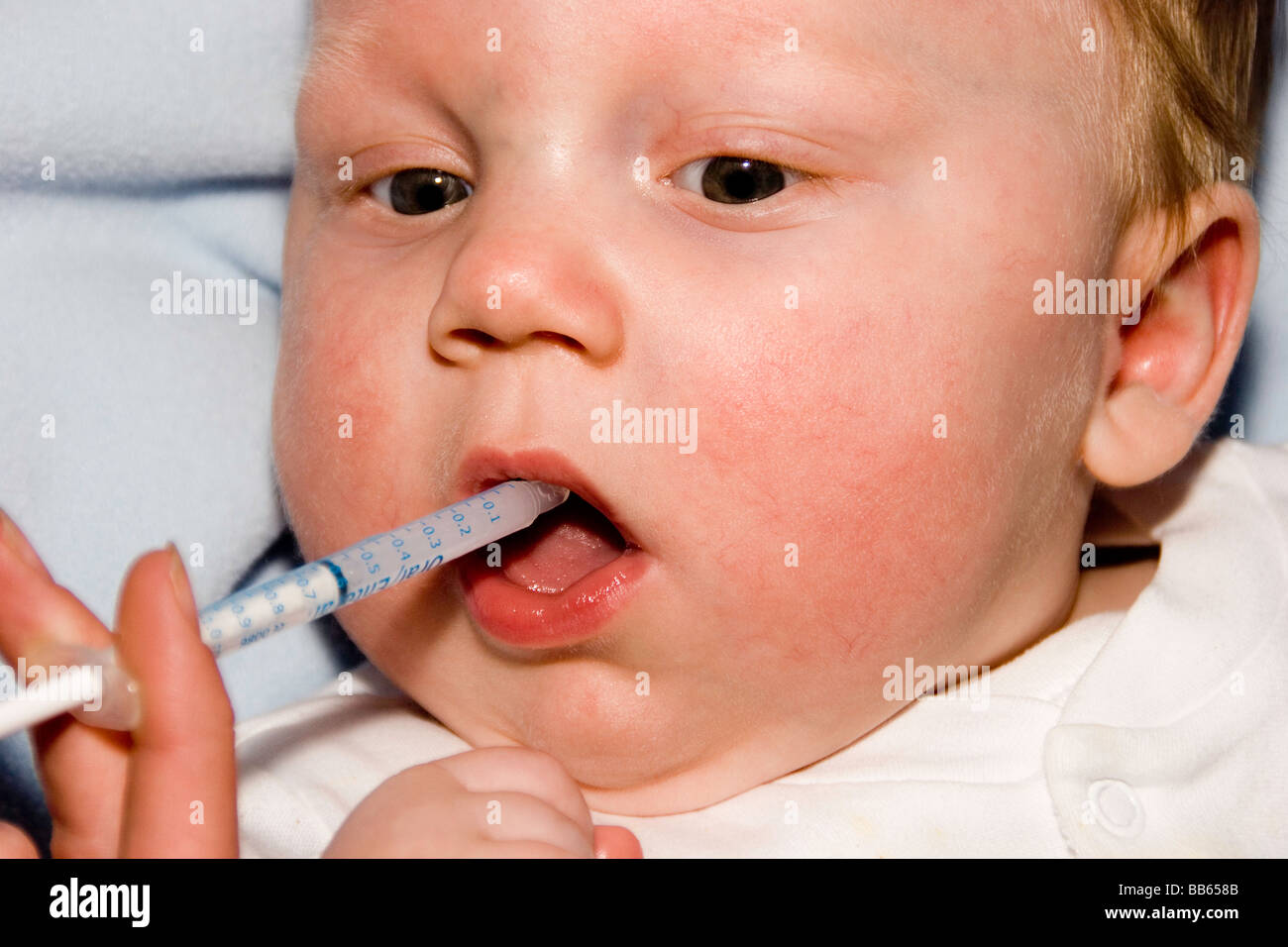 sick baby taking medicine from a syringe Stock Photo Alamy