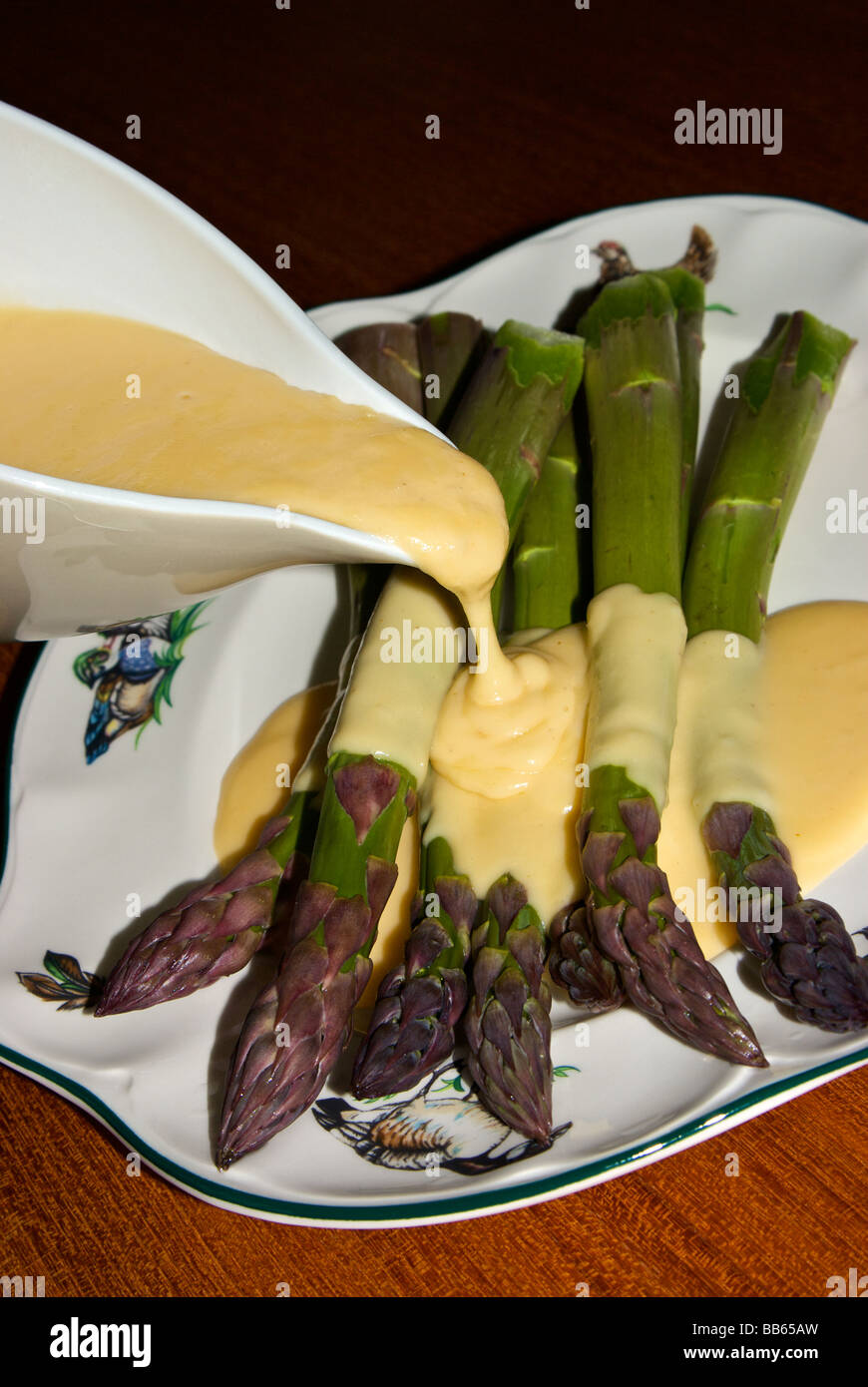 Thick stalks steamed asparagus with cheddar cheese sauce Stock Photo