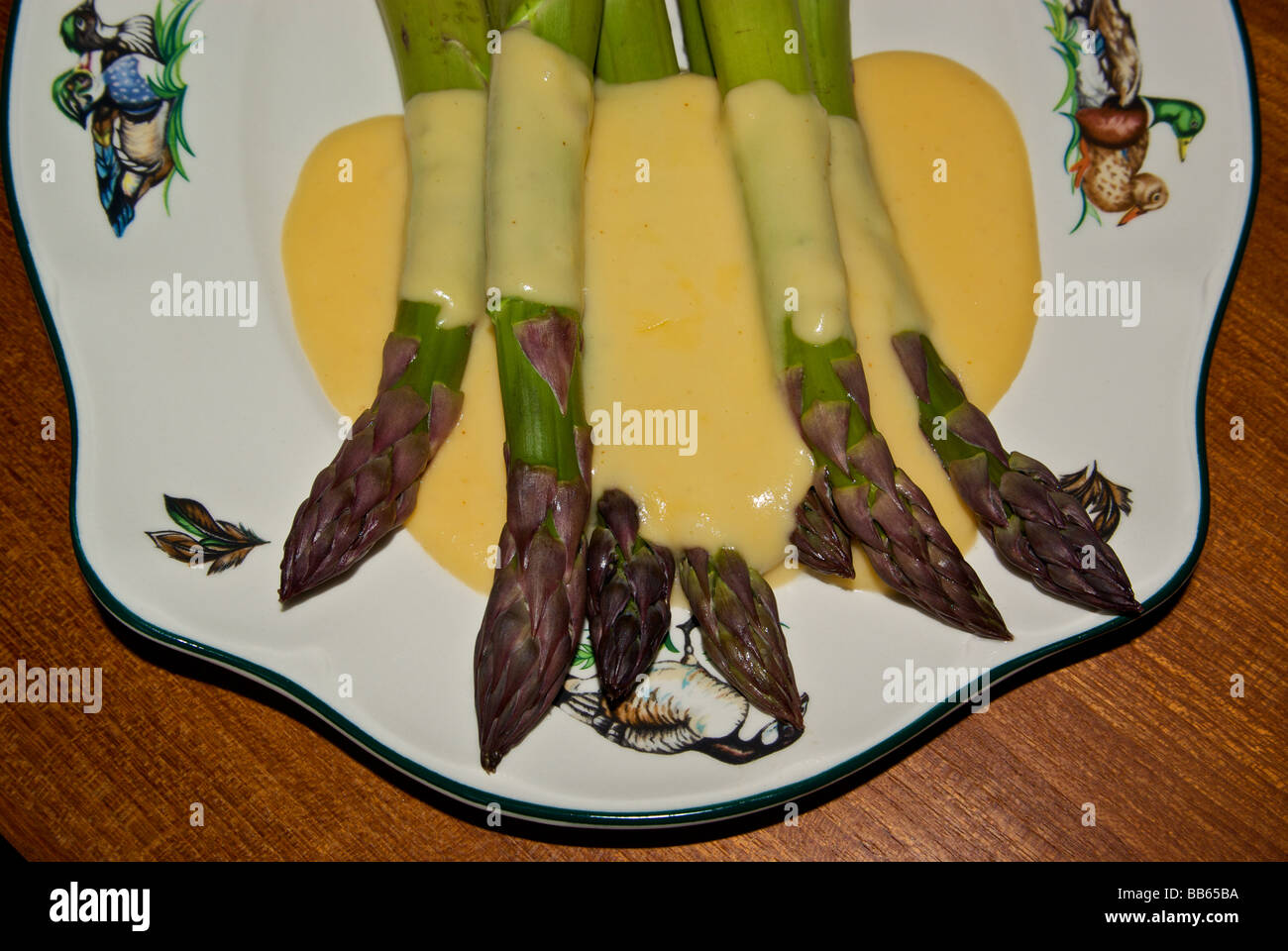 Thick stalks steamed asparagus with cheddar cheese sauce Stock Photo