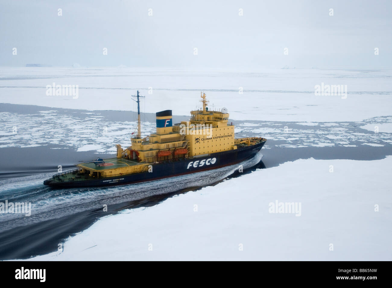 Russian Icebreaker expedition Cruise Ship moving through thick ice pack  in Antarctica people and helicopter on deck Stock Photo