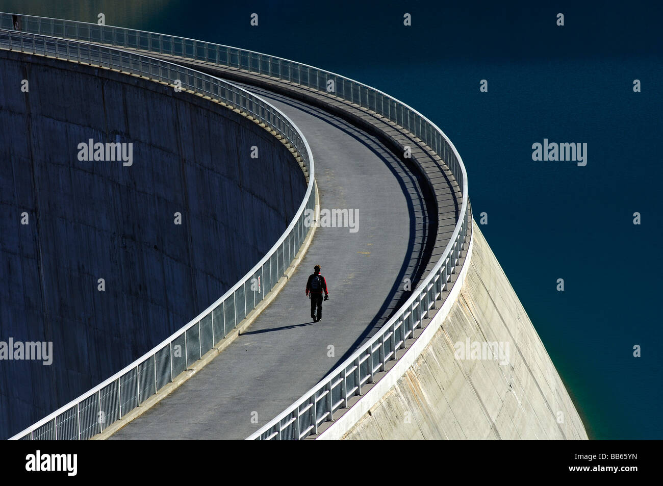 Pedestrian on the dam crest of the concrete gravity arch dam Moiry