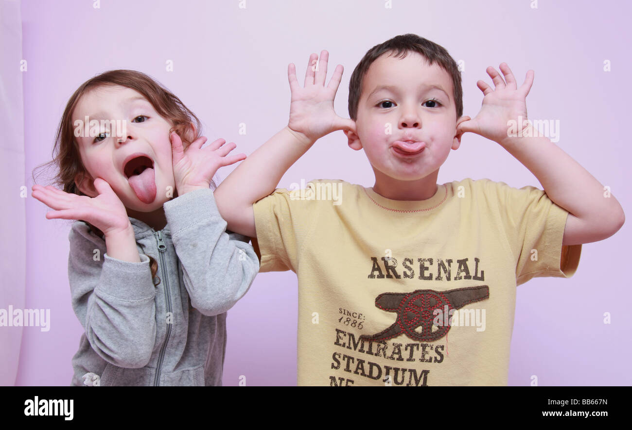 2 cheeky children pulling faces Stock Photo
