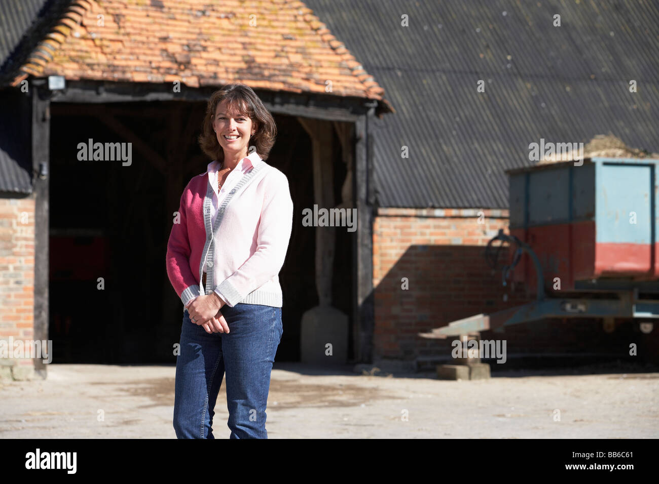 Farmer's Wife Standing In Front Of Farm Buildings Stock Photo - Alamy