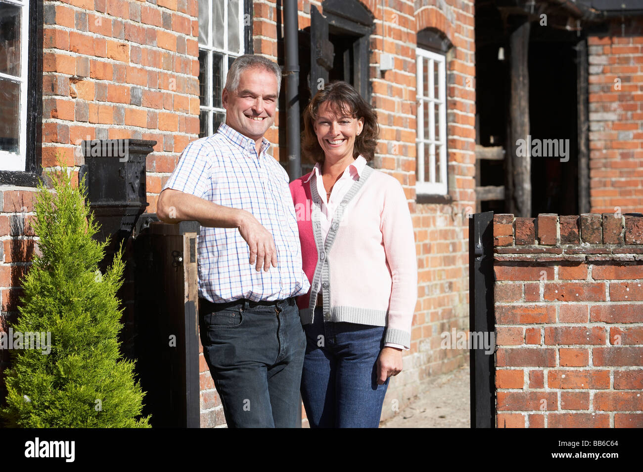Farmer And Wife Standing In Front Of Farmhouse Stock Photo - Alamy