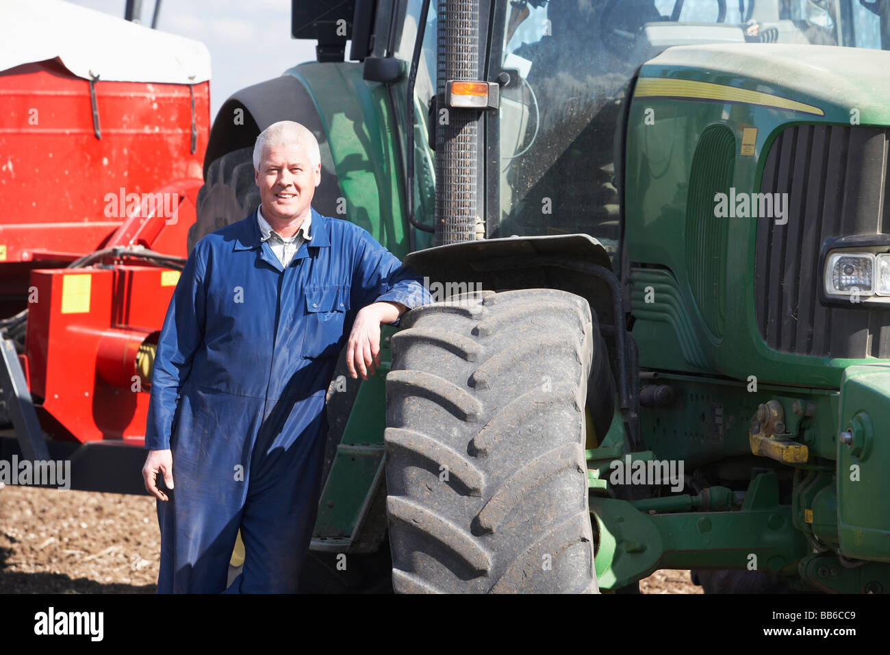 Driver Standing In Front Of Tractor Stock Photo
