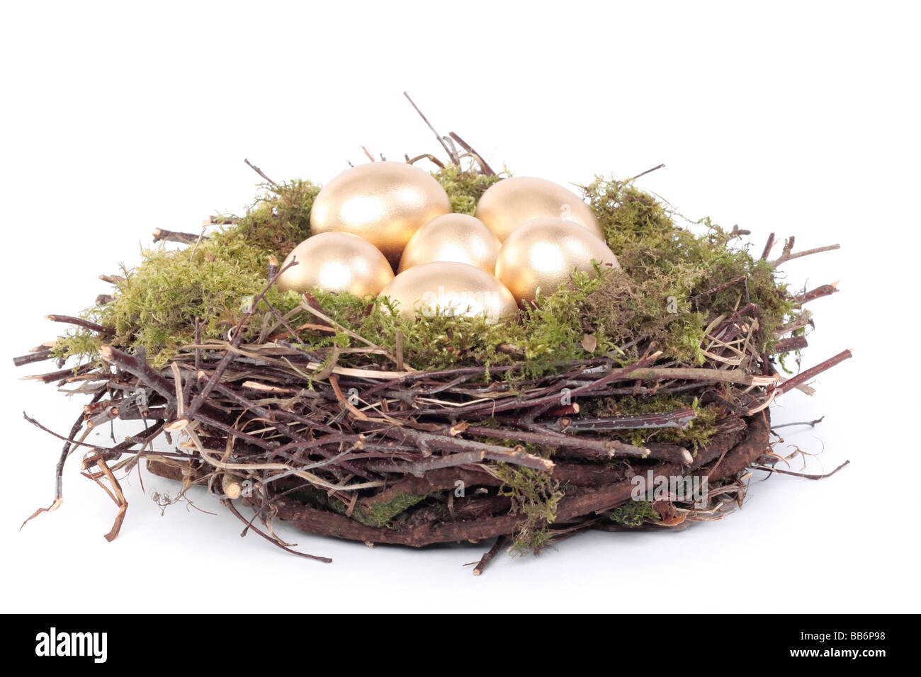 Golden eggs in bird nest over white background Stock Photo - Alamy