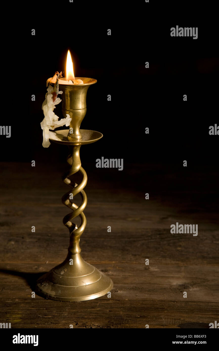 A brass candlestick with a near burn't out candle. Stock Photo