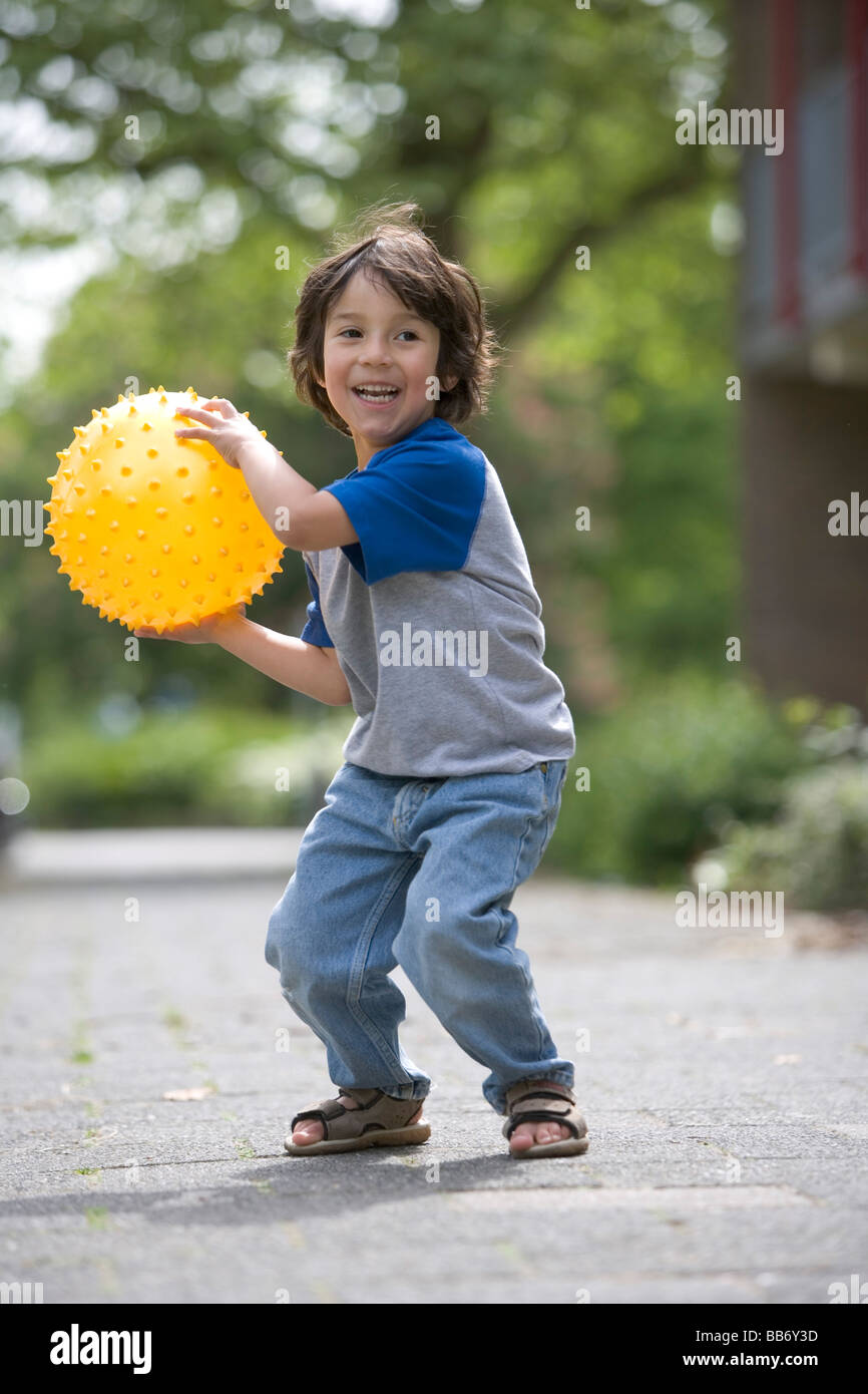 Little boy throwing a yellow ball Stock Photo Alamy