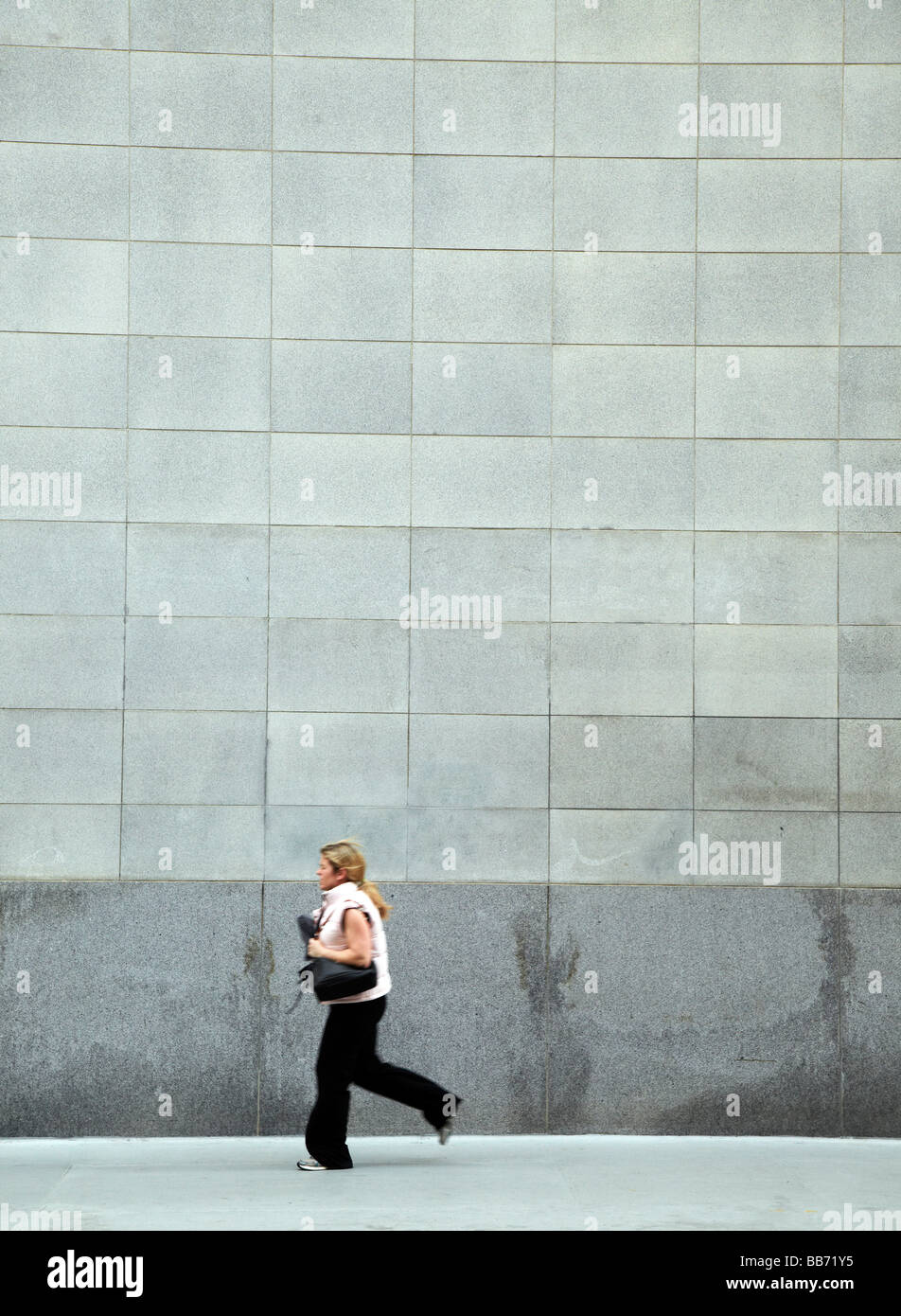 Woman walking sidewalk gray wall hi-res stock photography and images ...