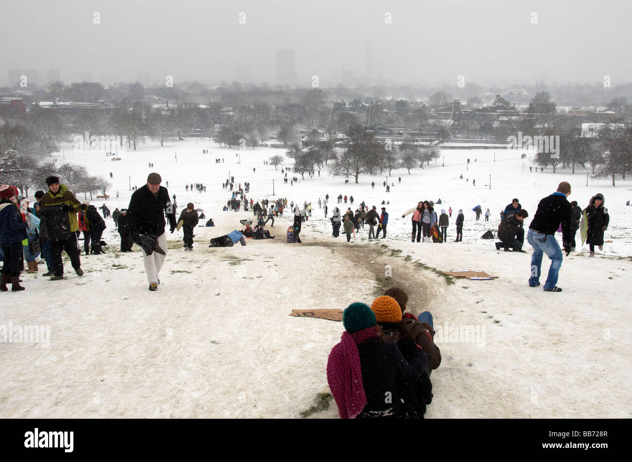 People tobogganing Primrose Hill in winter after snowfall London NW1 England UK Stock Photo