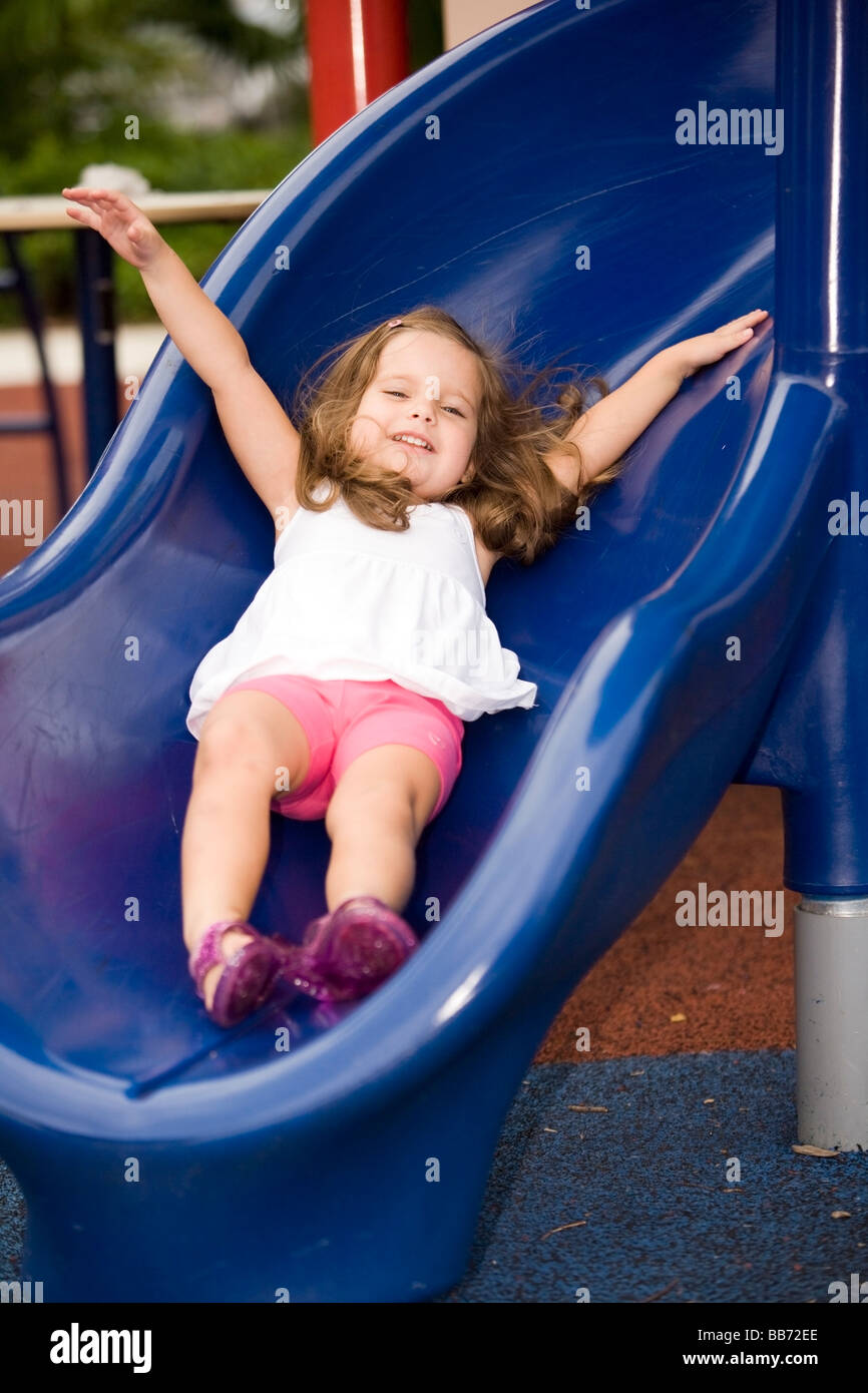 Young girl sliding down slide at playground - Fort Lauderdale