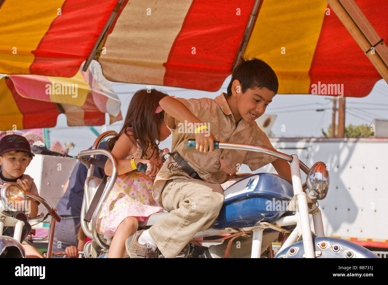 A young boy riding a make belive motorcyle at a carnival Stock Photo ...