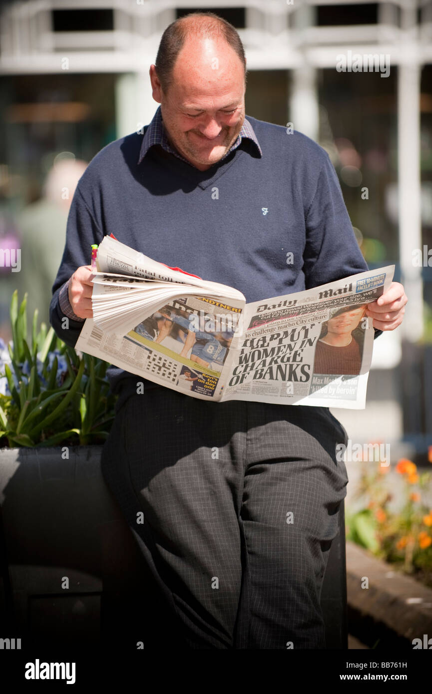 A middle aged man reading the tabloid Daily Mail newspaper UK Stock Photo