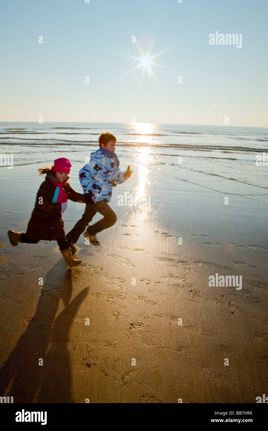 [Children running] on beach in winter Stock Photo
