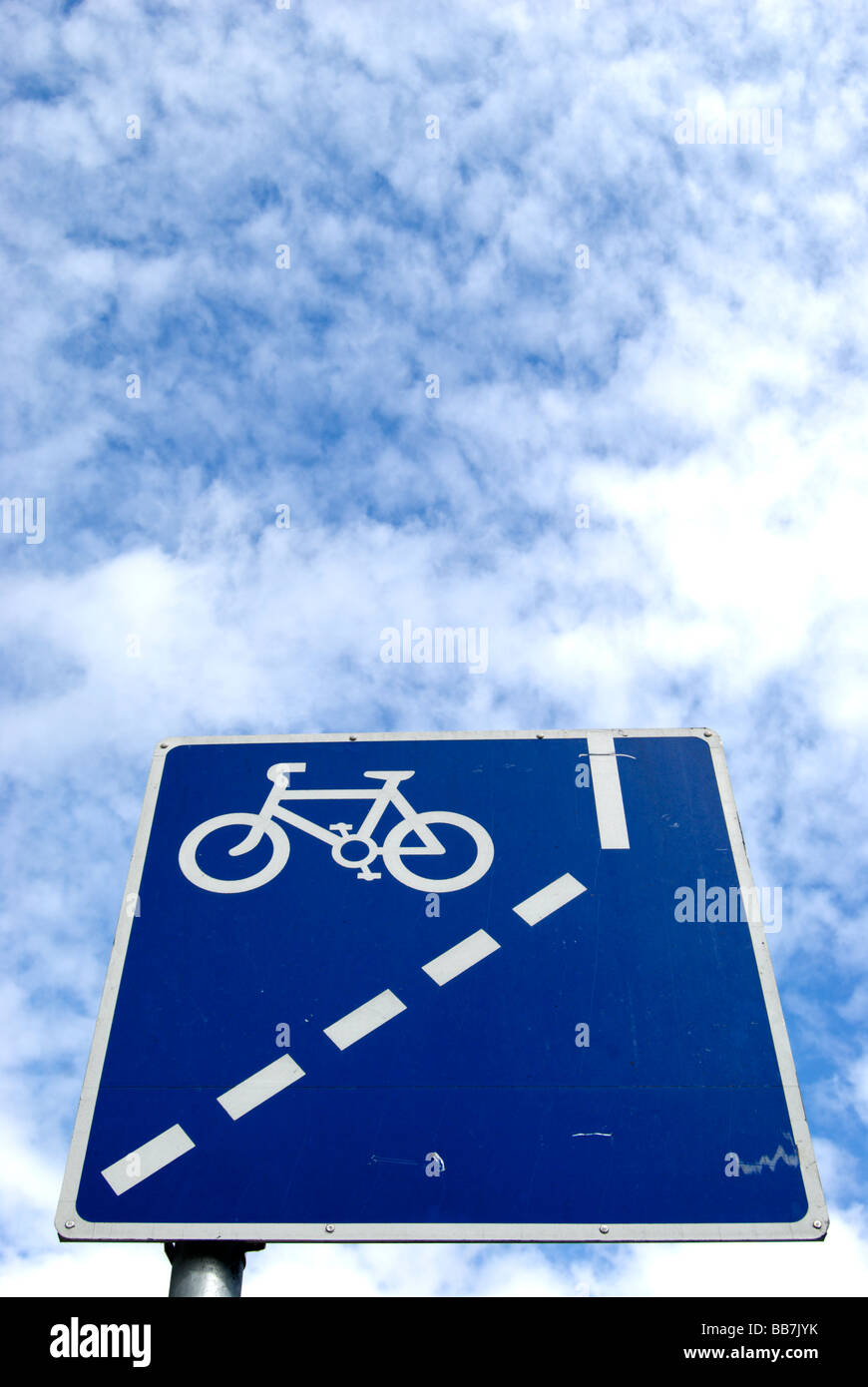 seen under a mottled sky of patch work cirrocumulus cloud british blue and white road sign indicating mandatory cycle lane ahead Stock Photo