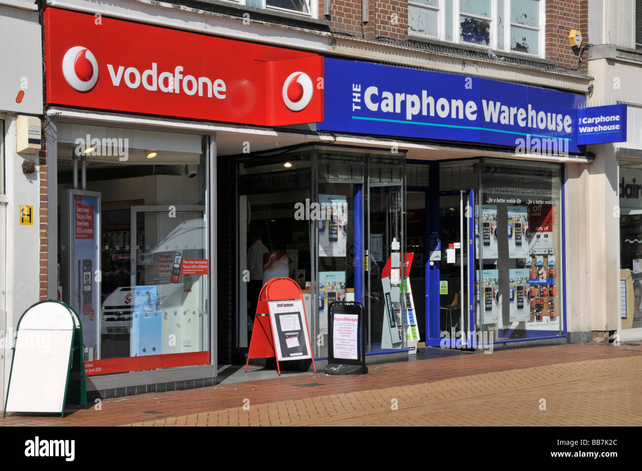 Chelmsford town centre Vodaphone & Carphone Warehouse mobile phone retail business shop front window in adjacent high street premises Essex England UK Stock Photo