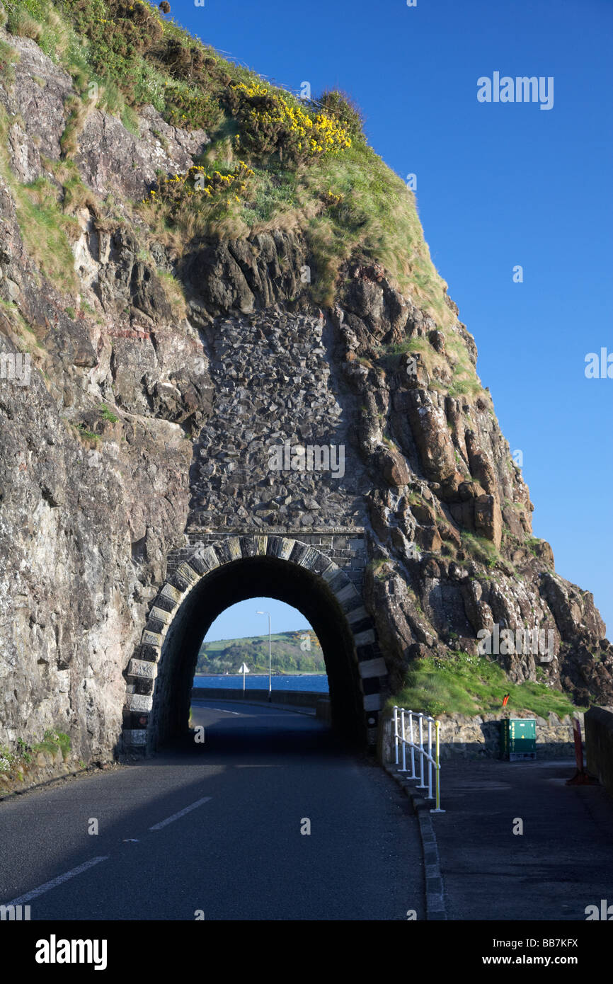 The A2 causeway coastal route coast road passes through the black arch blackcave tunnel outside Larne in County Antrim Northern Ireland UK Stock Photo