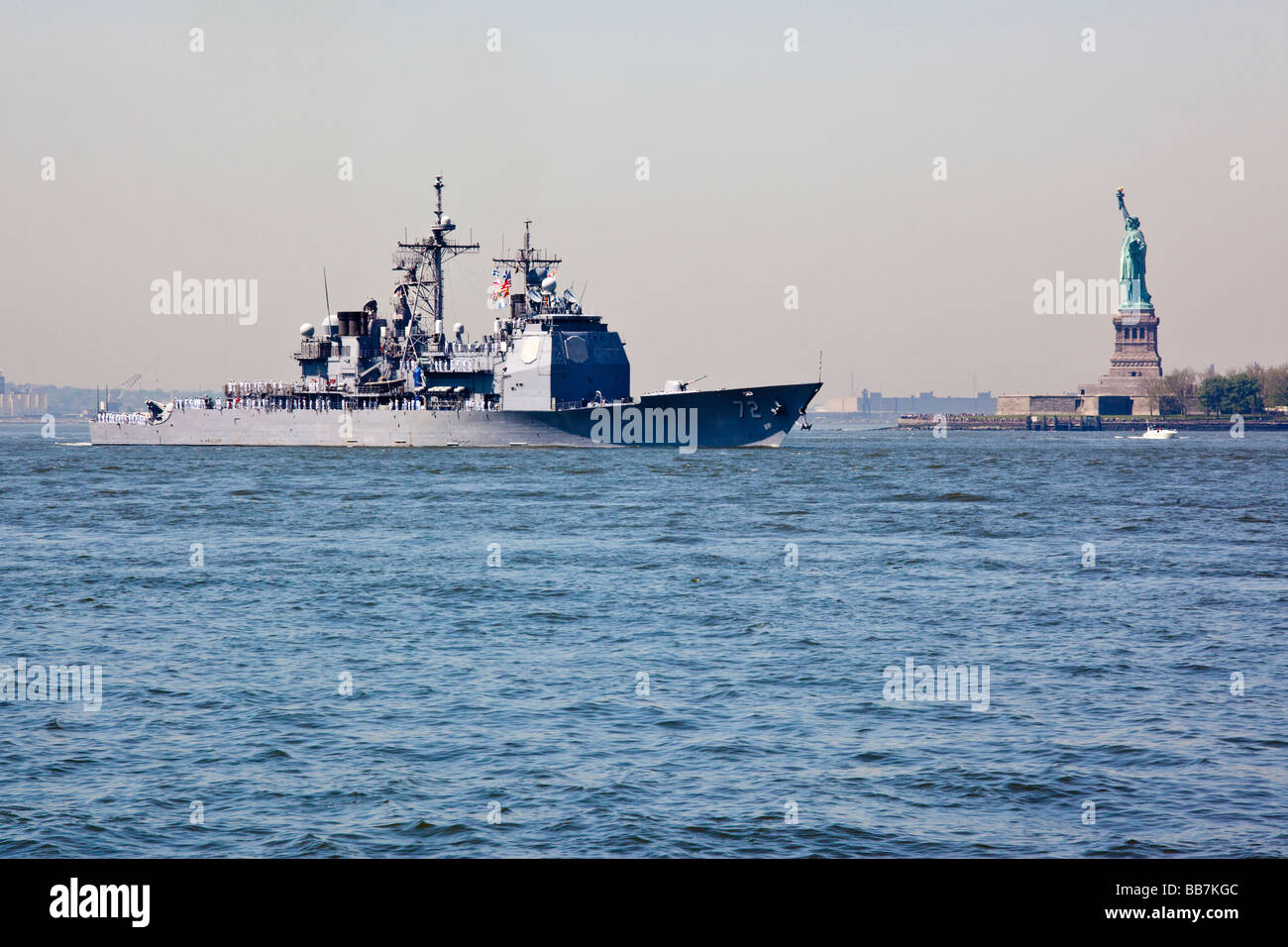 Naval Warship passes in front of the Statue of Liberty in New York during Fleet Week Stock Photo