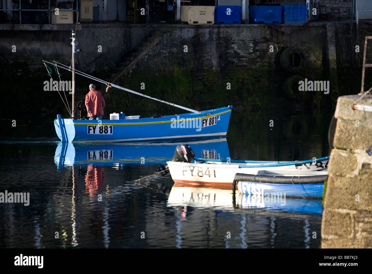 A fisherman sets sail in the morning from Mevagissey harbour, Cornwall, UK Stock Photo