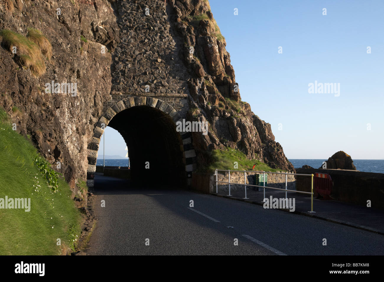 The A2 causeway coastal route coast road passes through the black arch outside Larne in County Antrim Northern Ireland UK Stock Photo
