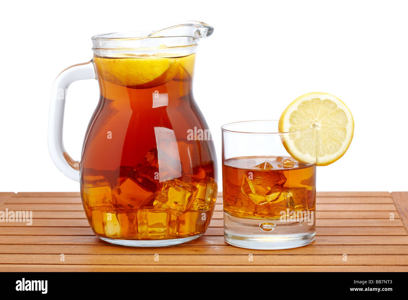 Ice tea pitcher and glasss with lemon and icecubes on wooden background Shallow depth of field Stock Photo