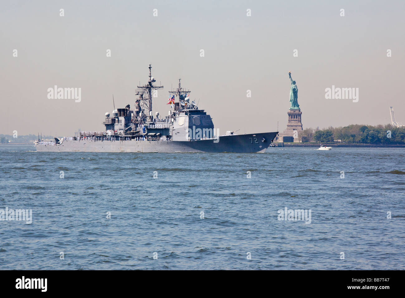 Naval Warship passes in front of the Statue of Liberty in New York during Fleet Week Stock Photo