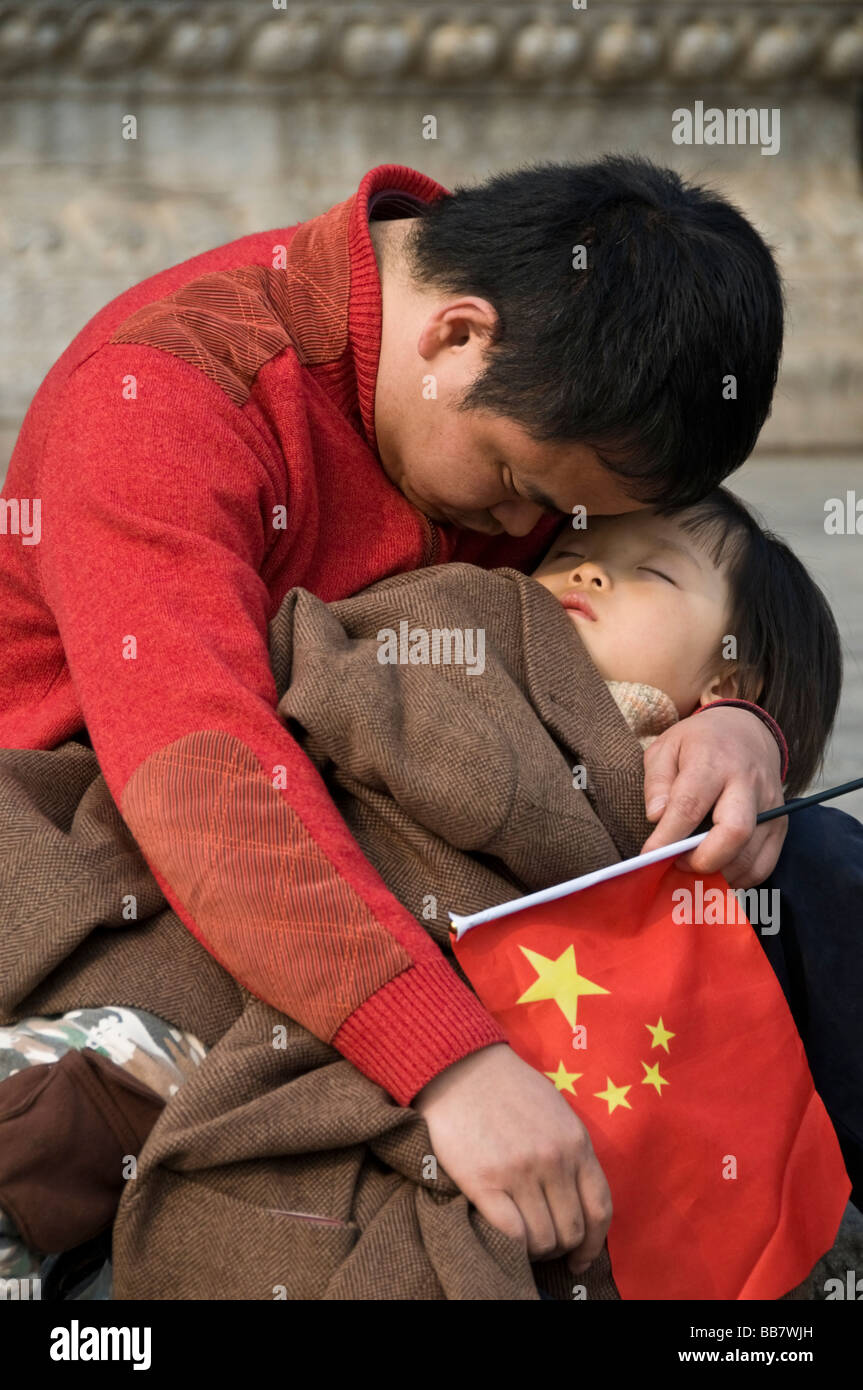 A man and his young son have a nap after a long day as tourists in the Forbidden City Beijing Stock Photo