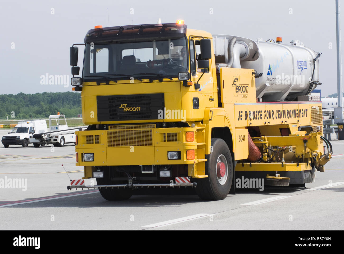 Bright Yellow Road Sweeping Truck in the Apron Area at Geneva Airport Switzerland Geneve Suisse Stock Photo