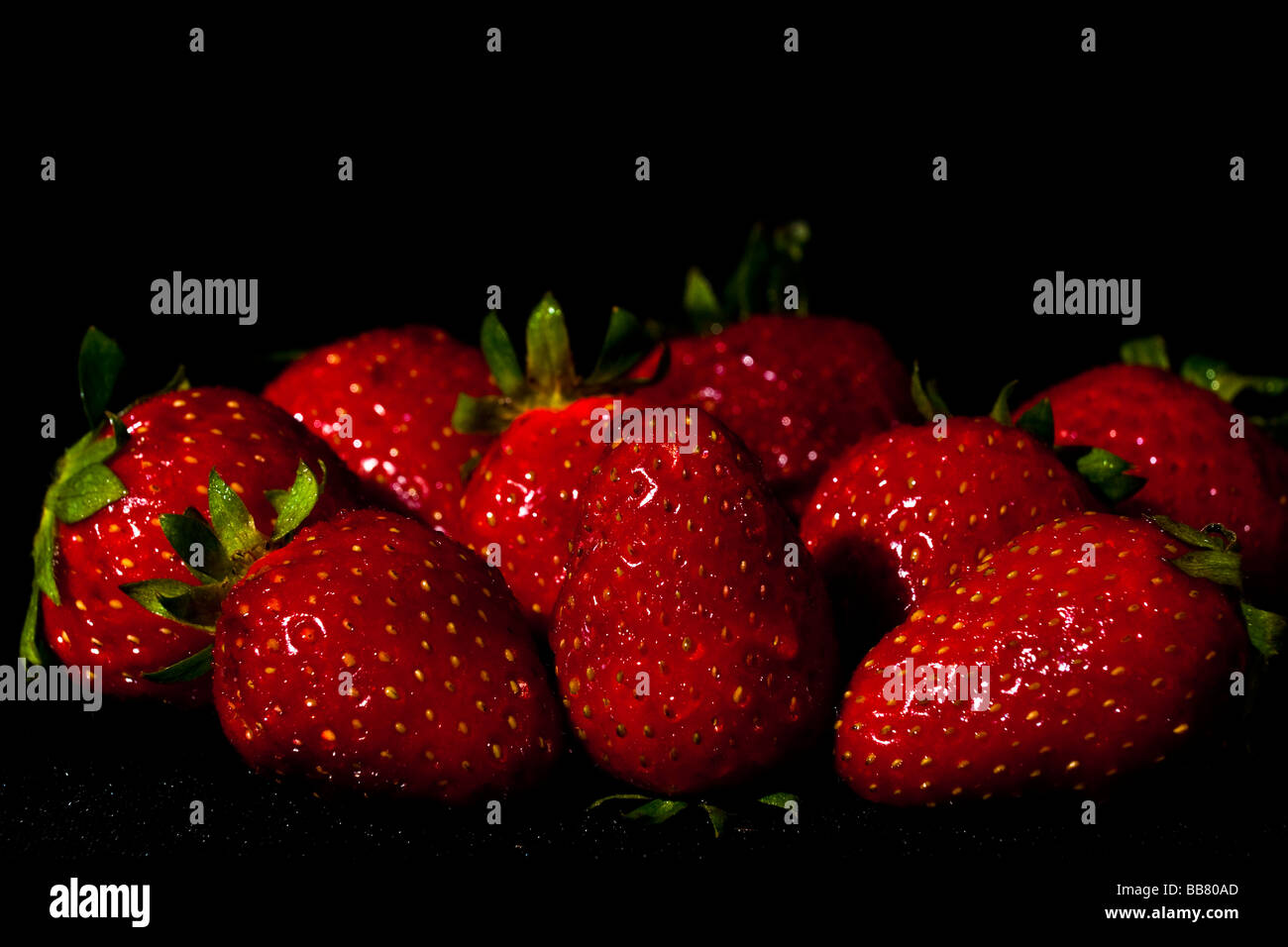 Strawberries on black background Stock Photo - Alamy