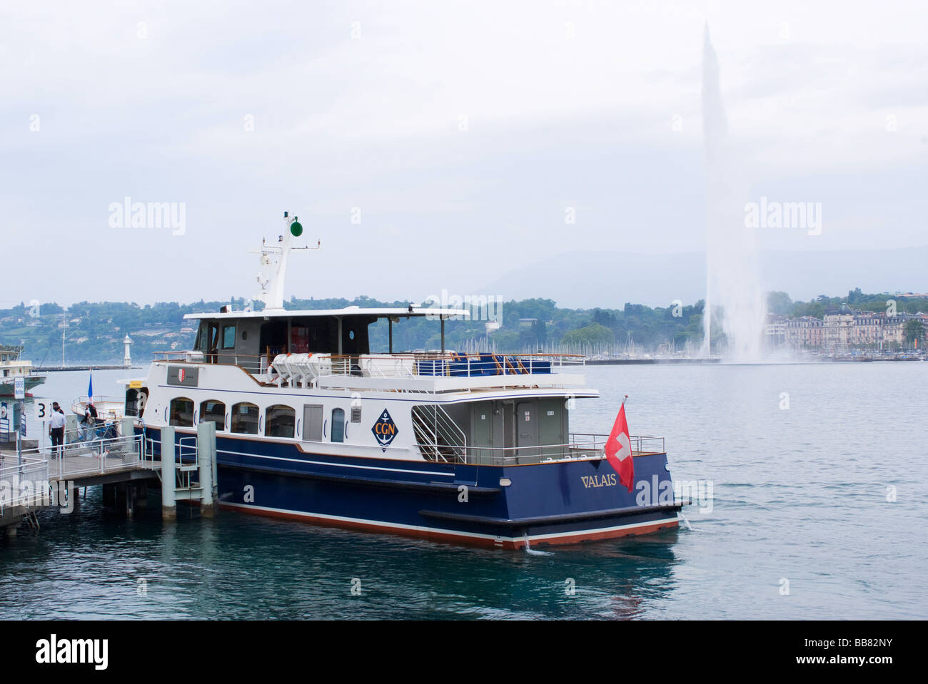 The Tourist Boat Valais Docked in Lake Geneva with Jet D'Eau in Background Geneva Switzerland Stock Photo