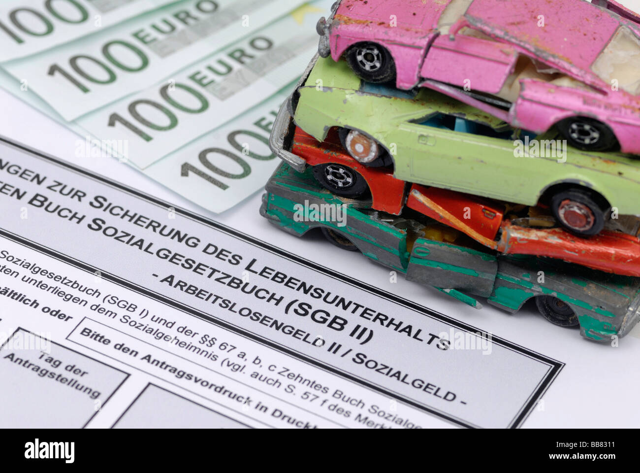 Broken miniature cars on an unemployment benefit form, symbolic picture for scrapping premium for Hartz-IV recipients Stock Photo