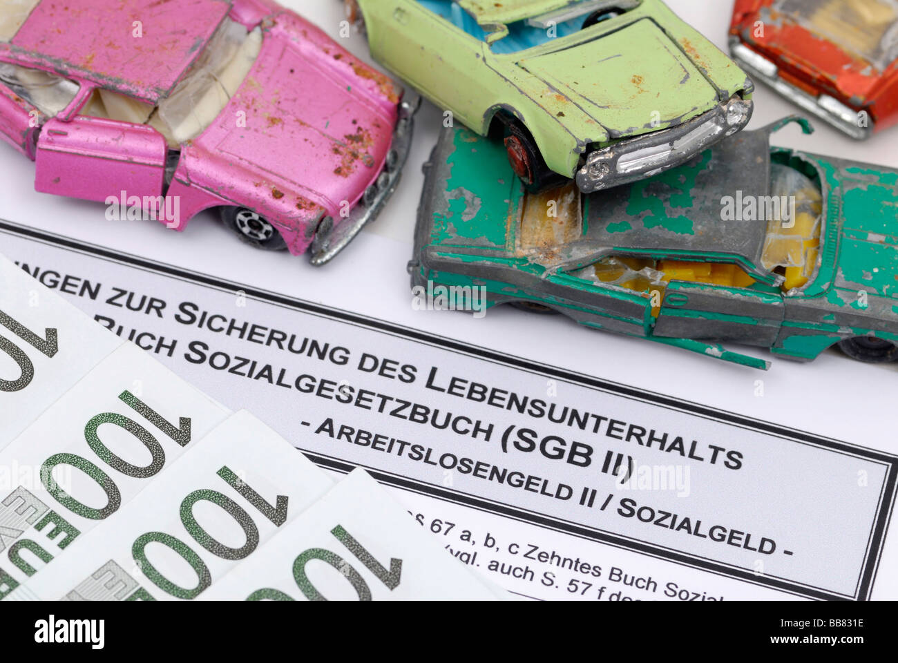 Broken miniature cars on an unemployment benefit form, symbolic picture for scrapping premium for Hartz-IV recipients Stock Photo