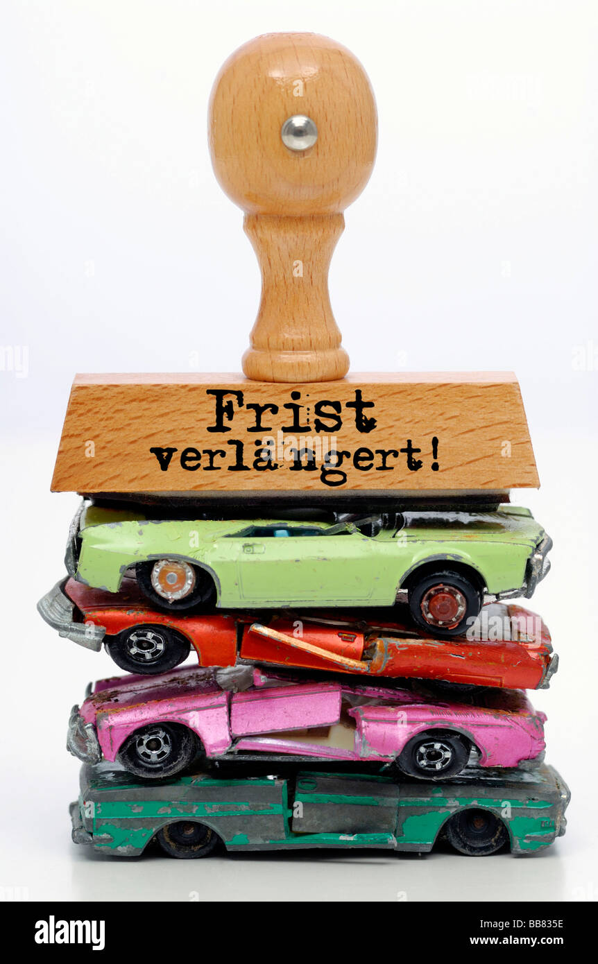 Stamp with lettering Frist verlaengert!, German for deadline extended, on broken miniature cars, extension of the environmental Stock Photo