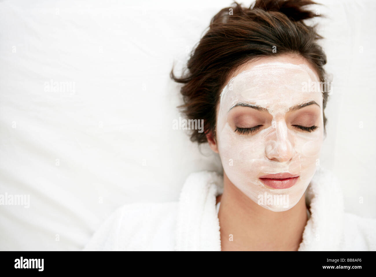 Portrait of young relaxing woman's face wearing face pack and closing eyes Stock Photo