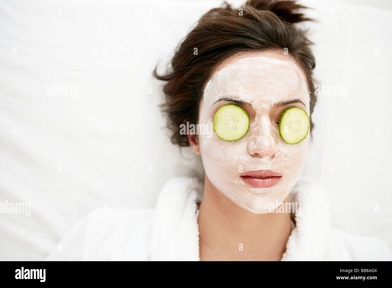 Portrait of young relaxing woman's face wearing face pack and closing eyes Stock Photo