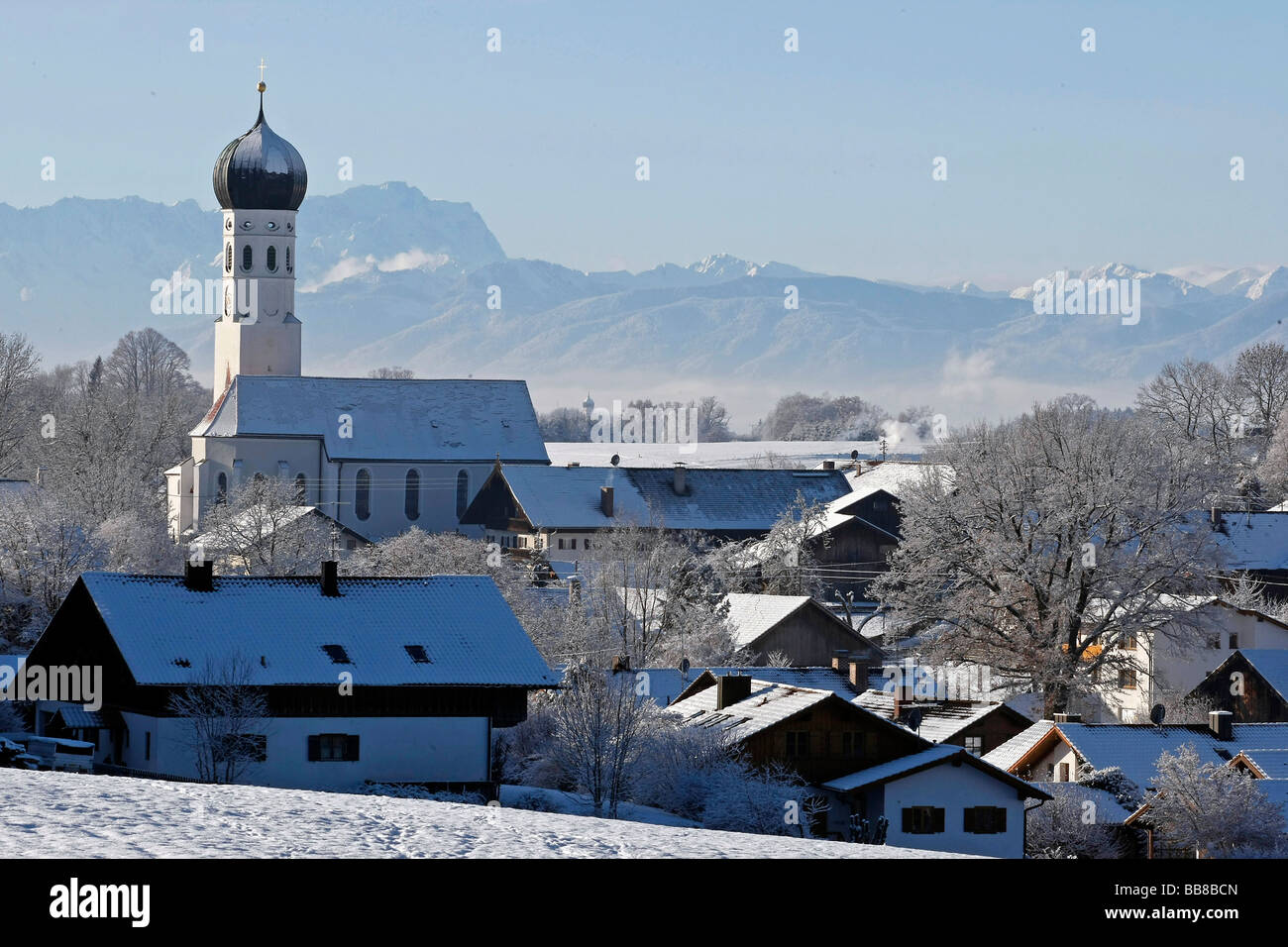 Church and alpine panorama with Mt. Zugspitze, winter impressions, Muensing, Bavaria, Germany Stock Photo
