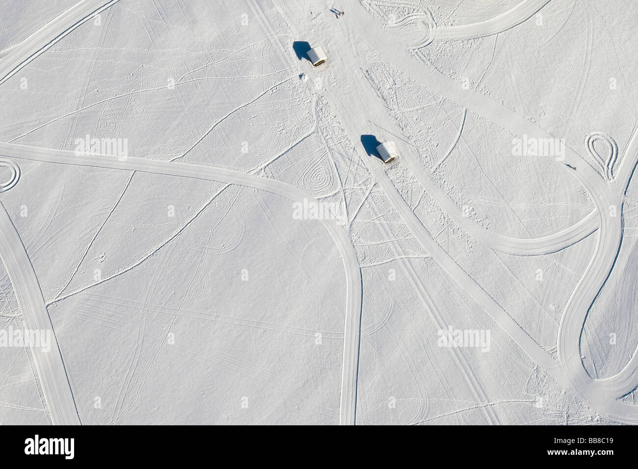 Two sheds in snow surrounded by ski tracks and cross-country ski runs, Chiemgau, Upper Bavaria, Bavaria, Germany Stock Photo