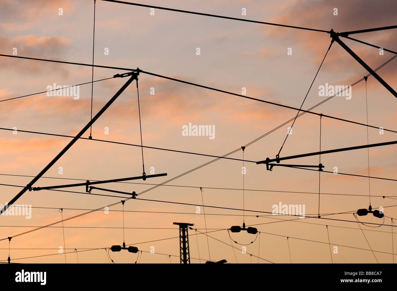 Commuter railway system and German Federal Railways catenary in sunset light Stock Photo