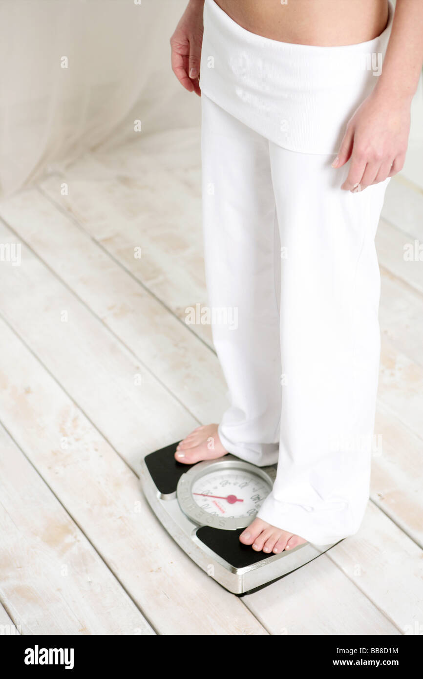 Cut out of young woman standing on a scale Stock Photo