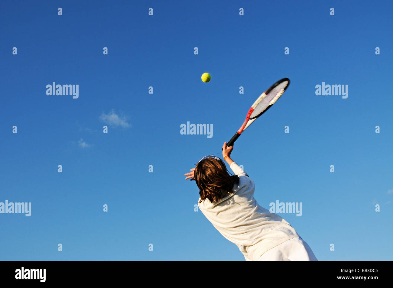 action shot of girl hitting tennis ball Stock Photo