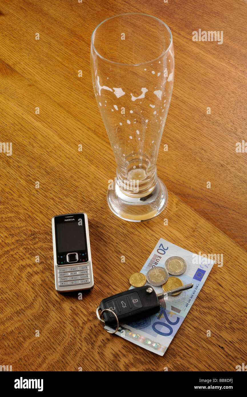 Empty glass of wheat beer, car keys, symbolic of drink-driving Stock Photo