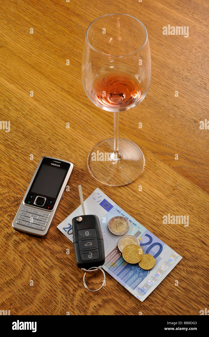 Empty glass of red wine, car keys, symbolic of drink-driving Stock Photo