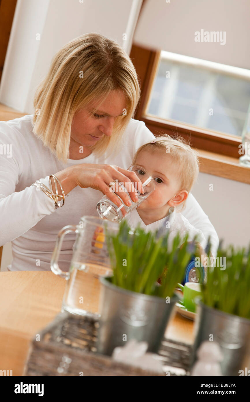 Mother Helping Her 1 Year Old Daughter To Drink Water From A Glass Stock Photo Alamy