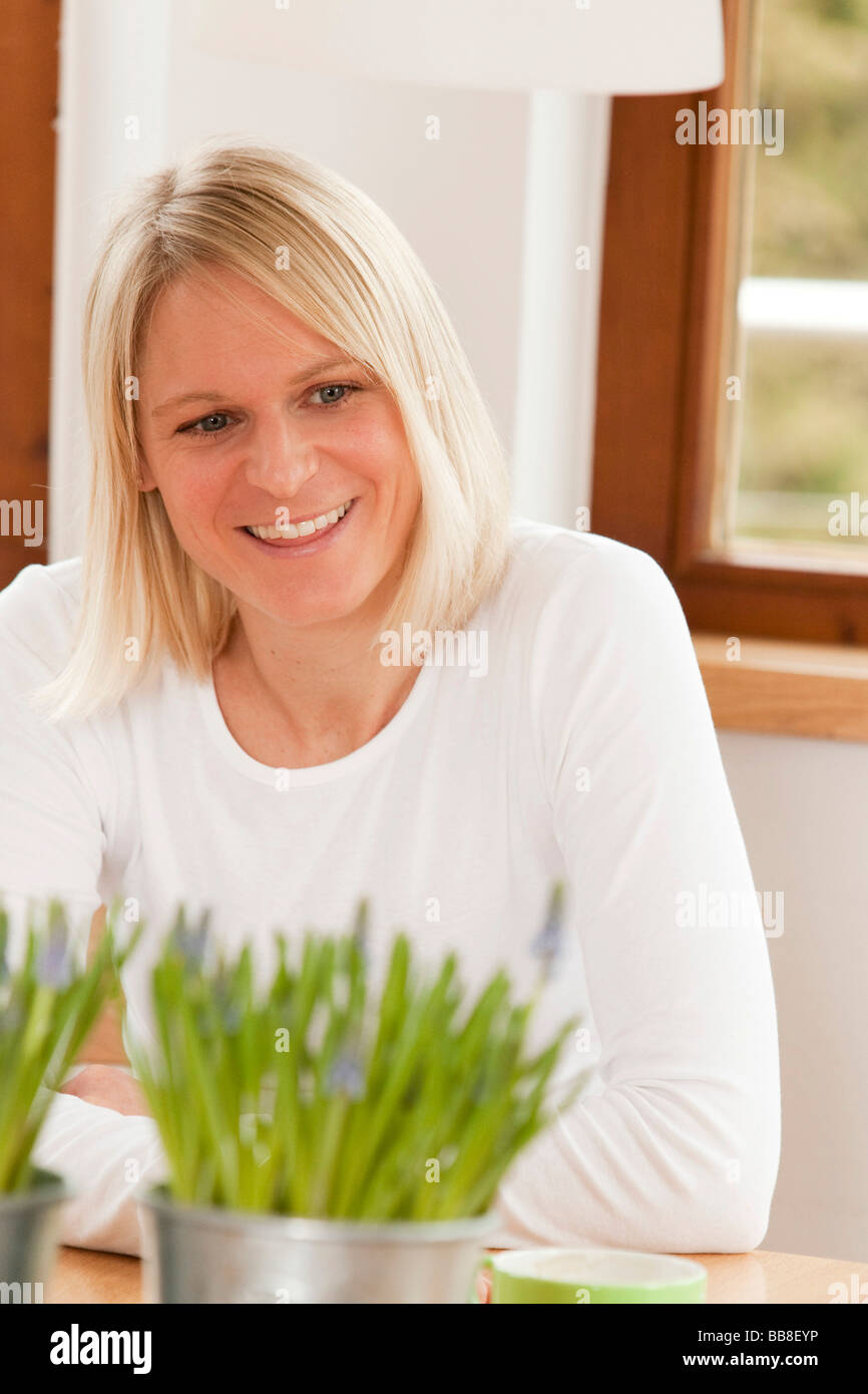 Woman sitting at the dining table, smiling Stock Photo