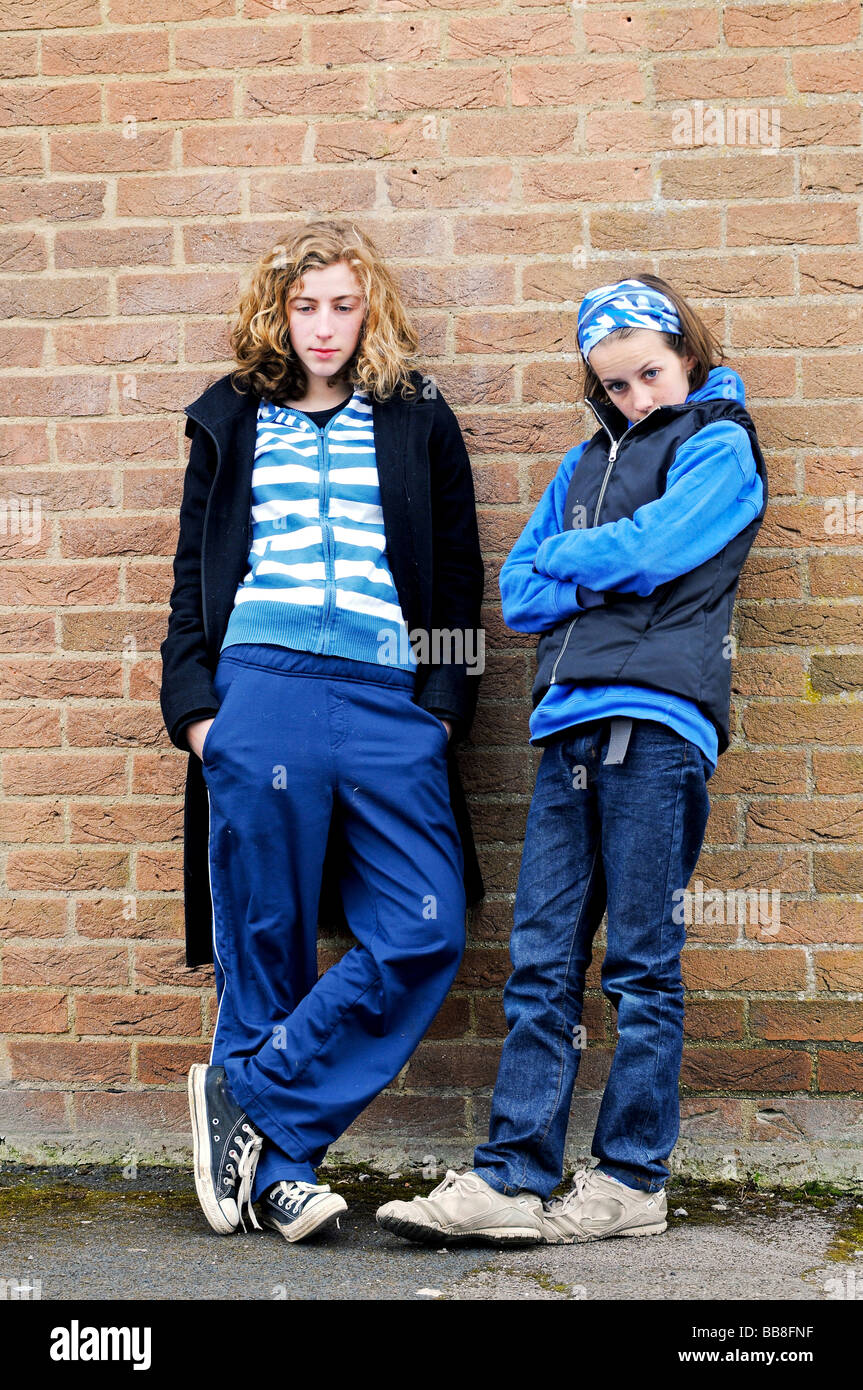 portrait of teenage girls against a brick wall Stock Photo